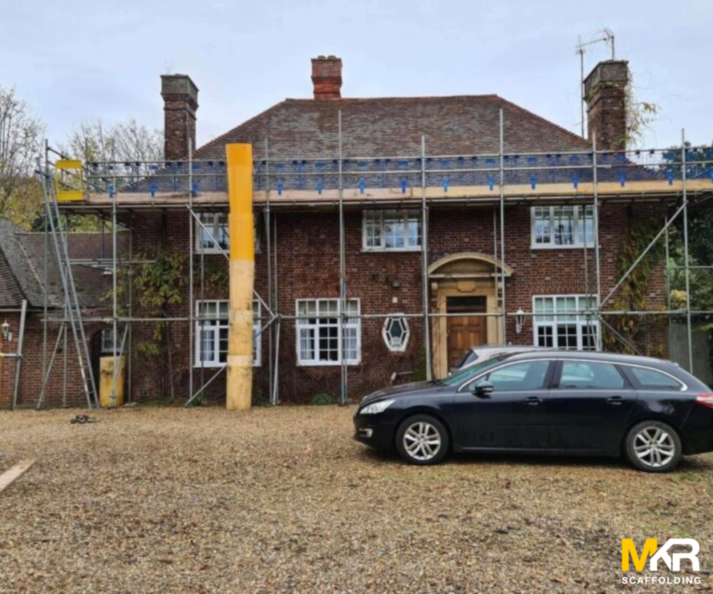 Rubbish chute running down a scaffold on a brick house