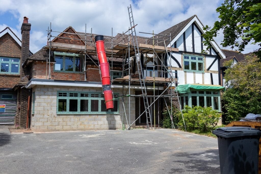 Rubbish chute fixed to scaffolding on a house during refurbishment